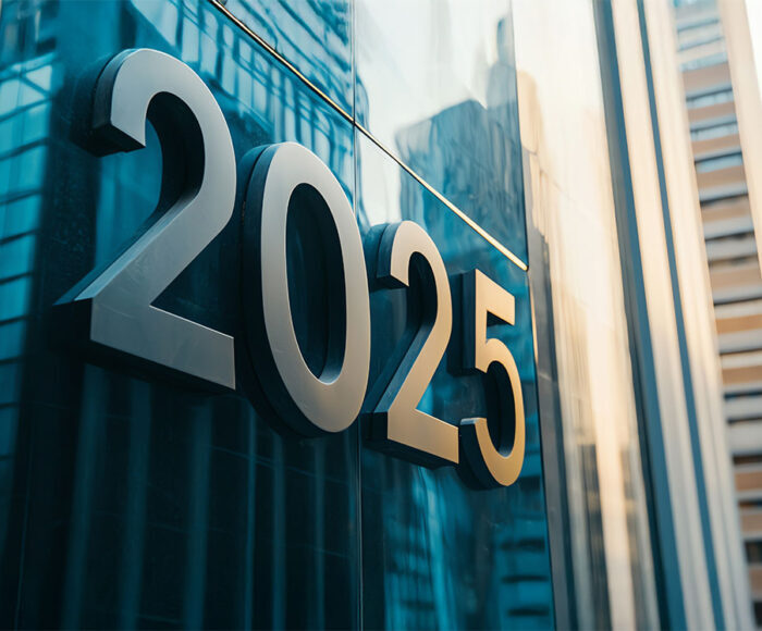 Number 2025 in sleek black letters on a modern glass skyscraper entrance